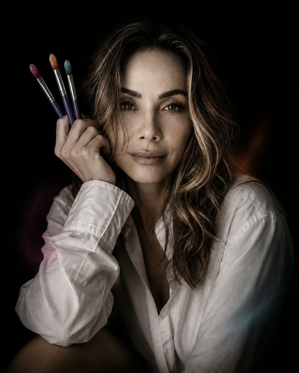 Tia Castle holding three paintbrushes